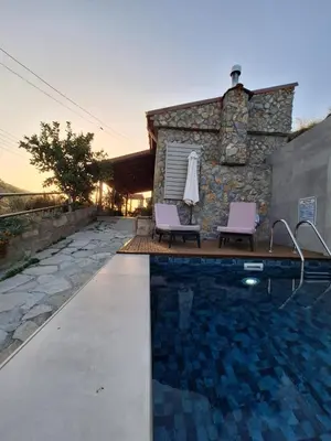 a swimming pool with two chairs and a building at Jennas House in Arakapas
