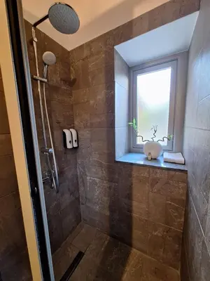 a bathroom with a shower with a window at Jennas House in Arakapas