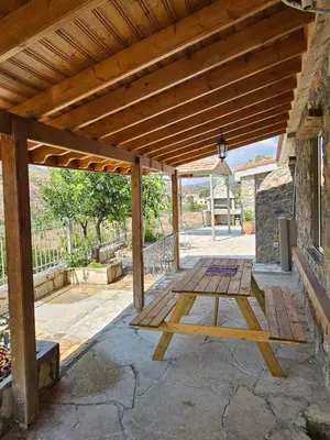 a wooden picnic table under a wooden roof at Jennas House in Arakapas