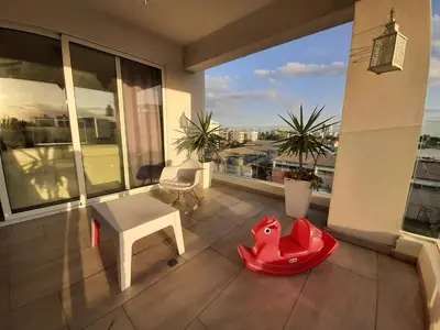 a balcony with a table and a red dog toy at Happy Tucan in Larnaka