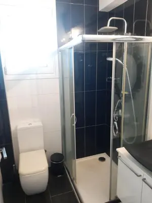 a bathroom with a toilet and a glass shower at Happy Tucan in Larnaka