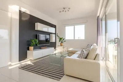 a living room with a white couch and a tv at Happy Tucan in Larnaka
