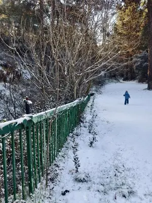 a person walking in the snow next to a fence at Rifugio Retreat in Kakopetria