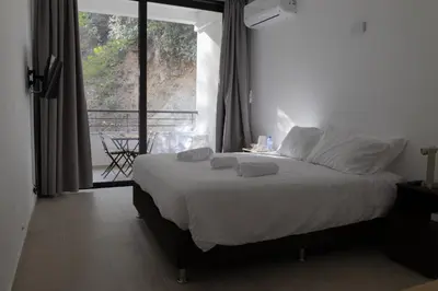 a bedroom with a bed with white sheets and a window at Rifugio Retreat in Kakopetria