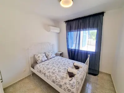 a bedroom with a white bed and a window at Beach Vibes Beachfront Apartment in Pyla