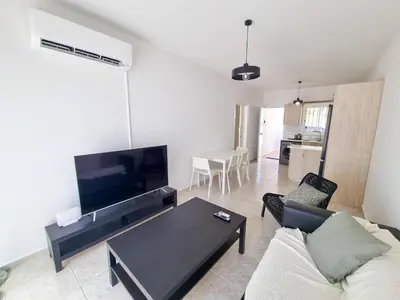 a living room with a couch and a table at Beach Vibes Beachfront Apartment in Pyla
