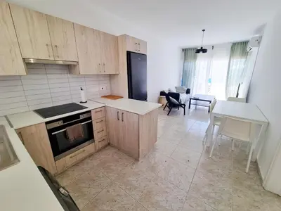a kitchen with wooden cabinets and a table and chairs at Beach Vibes Beachfront Apartment in Pyla