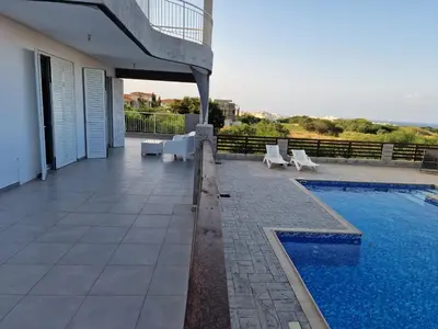 a house with a swimming pool next to a building at Kalifi Pool Apartment in Paralimni