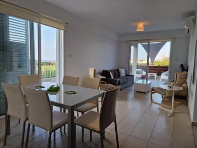 a living room with a table and chairs and a couch at Kalifi Pool Apartment in Paralimni