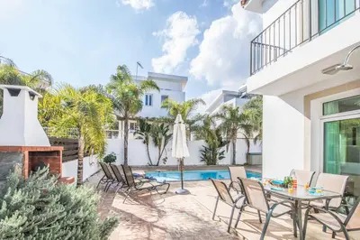 a patio with a table and chairs and a fireplace at Villa Armostia in Protaras