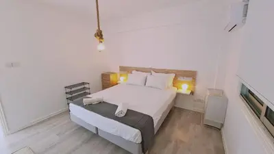 a bedroom with a large white bed and a desk at STAY Monte Elias Apartment in Protaras