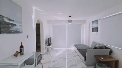 a white living room with a couch and a table at STAY Monte Elias Apartment in Protaras