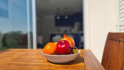 a bowl of fruit sitting on a wooden table at STAY Monte Elias Apartment in Protaras