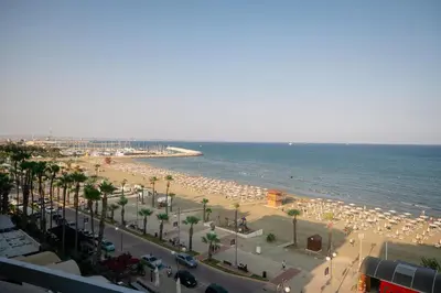 a beach with a lot of umbrellas and the ocean at Quattro Beachfront Sea View Ap 53 in Larnaka