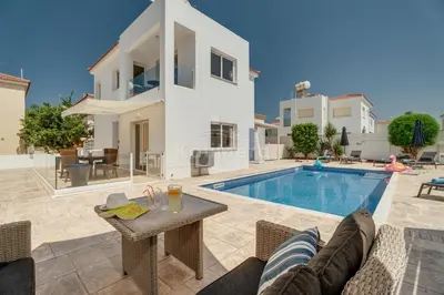 a villa with a swimming pool and a house at Villa Maddie in Protaras