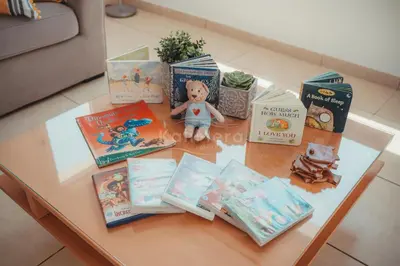 a table with books and a teddy bear on top at Villa Maddie in Protaras