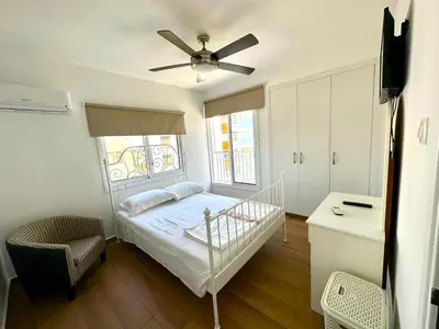 a bedroom with a bed and a ceiling fan at Sea View Apt - 2 min walk to the Beach & 200 Mbit Highspeed internet in Larnaka