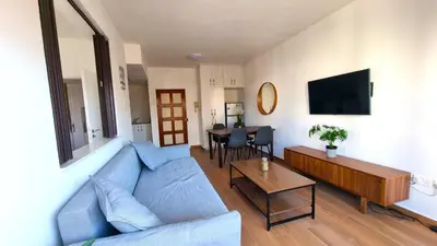 a living room with a blue couch and a table at Sea View Apt - 2 min walk to the Beach & 200 Mbit Highspeed internet in Larnaka
