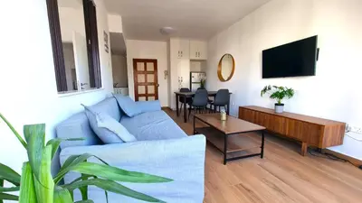 a living room with a blue couch and a table at Sea View Apt - 2 min walk to the Beach & 200 Mbit Highspeed internet in Larnaka