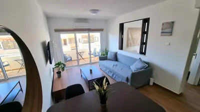 a living room with a couch and a table at Sea View Apt - 2 min walk to the Beach & 200 Mbit Highspeed internet in Larnaka