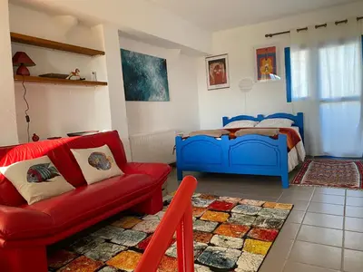 a bedroom with a bed and a red couch at Endless Sunset in Pendakomo