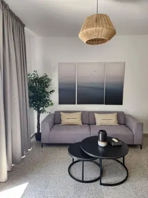 a living room with a couch and a table at Adamandri Lodge - Prime Location in Ayia Napa