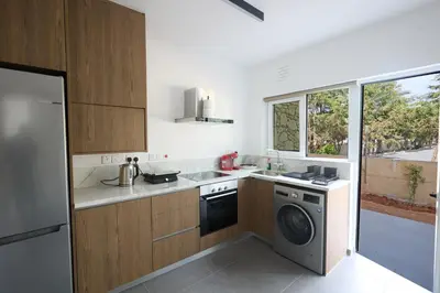 a kitchen with a washer and dryer in it at Adamandri Lodge - Prime Location in Ayia Napa