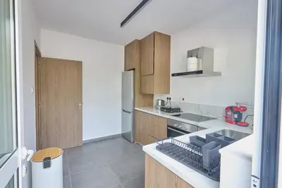 a kitchen with wooden cabinets and a stove top oven at Adamandri Lodge - Prime Location in Ayia Napa