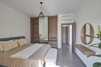 a bedroom with a large bed and a mirror at Adamandri Lodge - Prime Location in Ayia Napa
