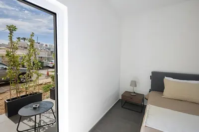 a room with a window and a bed and a table at Adamandri Lodge - Prime Location in Ayia Napa