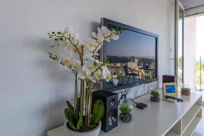 a white desk with a vase of flowers on it at Modern seafront apartment in Limassol