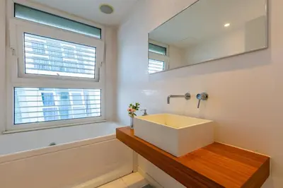 a bathroom with a white sink and a mirror at Modern seafront apartment in Limassol