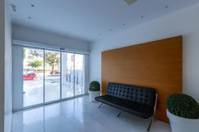 a waiting room with a bench and potted plants at Modern seafront apartment in Limassol