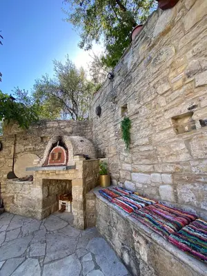 a stone wall with an outdoor oven in a yard at Lofitiko in Lofou