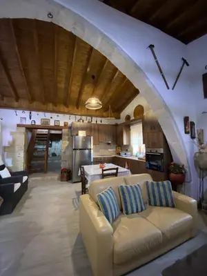 a living room with a couch and a kitchen at Lofitiko in Lofou