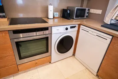 a kitchen with a washing machine and a sink at Quattro Beachfront Sea View Ap 4 in Larnaka