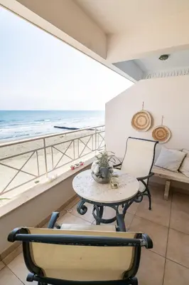 a table and chairs in a room with a view of the ocean at Quattro Beachfront Sea View Ap 4 in Larnaka