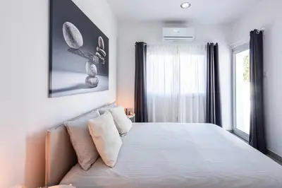 a bedroom with a large bed and a window at Kition City Apartments - Central Location in Larnaka