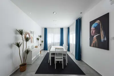 a dining room with a table and a painting on the wall at Kition City Apartments - Central Location in Larnaka