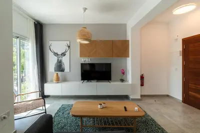 a living room with a table and a tv at Kition City Apartments - Central Location in Larnaka