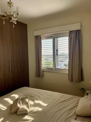 a bedroom with a large bed with a window at Beach apartment Mackenzie, Larnaca in Larnaka