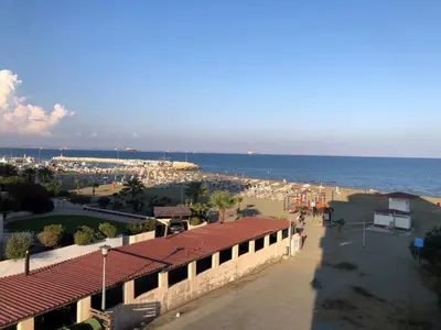 a view of a beach with a building and the ocean at Beach apartment Mackenzie, Larnaca in Larnaka