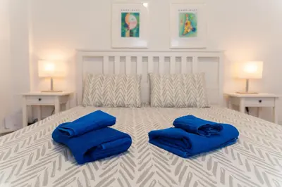 a bedroom with a bed with blue pillows on it at Finikoudes 3 Bedroom Seaview Flat in Larnaka