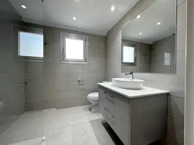 a bathroom with a sink and a toilet and two windows at Finikoudes 3 Bedroom Seaview Flat in Larnaka