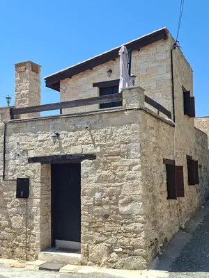 a stone building with a door and a flag on it at Symela's Nest in Anoyira