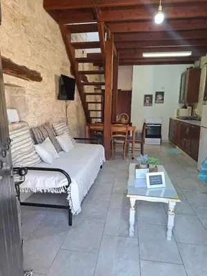 a bedroom with a bed and a table in a room at Symela's Nest in Anoyira