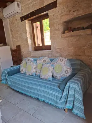 a blue bed in a room with a window at Symela's Nest in Anoyira