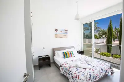 a bedroom with a bed and a large window at Protaras Greco Villa CCV1 in Protaras