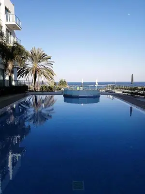 a large pool of blue water next to a building at Number 10 @ Coralli in Protaras