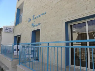a building with a blue railing in front of a store at St. Lazaros House in Larnaka